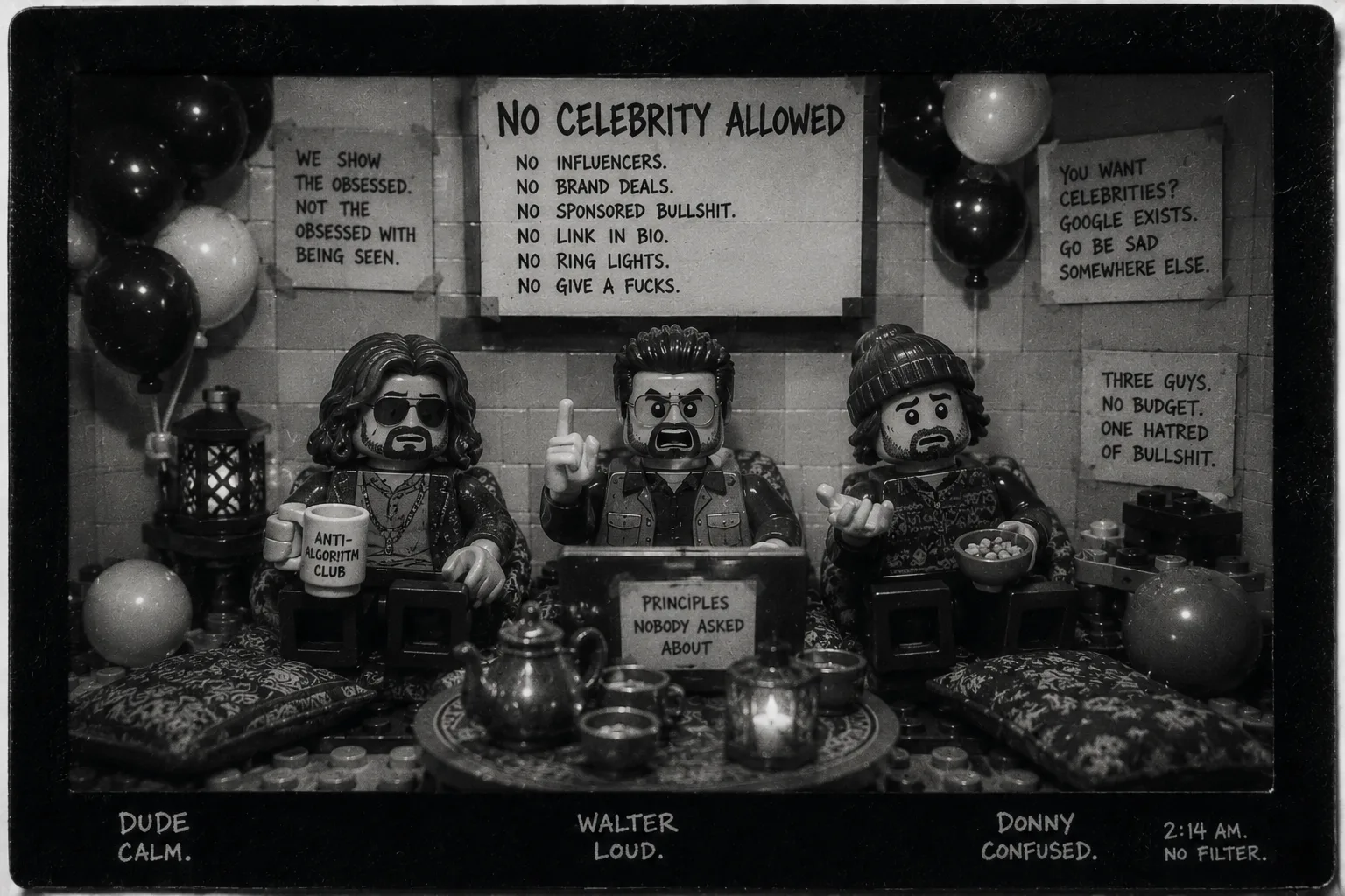 Black-and-white instant film of three toy figures sitting behind a low table in a balloon-filled room, under hand-lettered signs reading No Celebrity Allowed.
